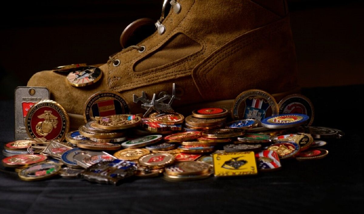 a pile of USMC challenge coins and RAT boots