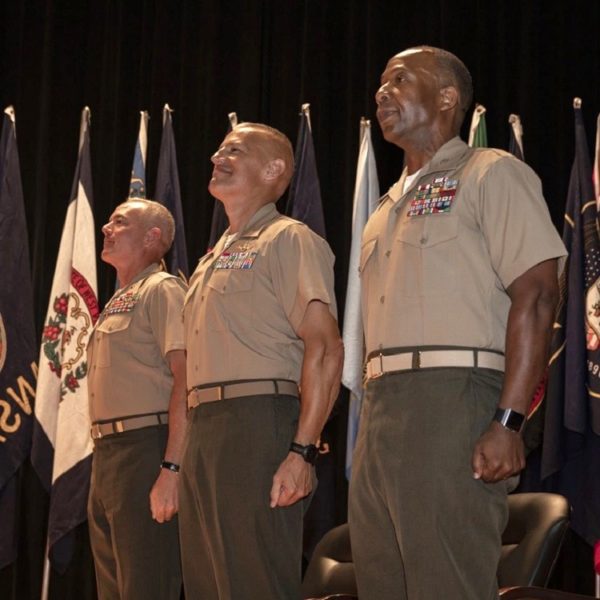 three Marine Corps officers wearing khaki web belts with anodized belt buckles