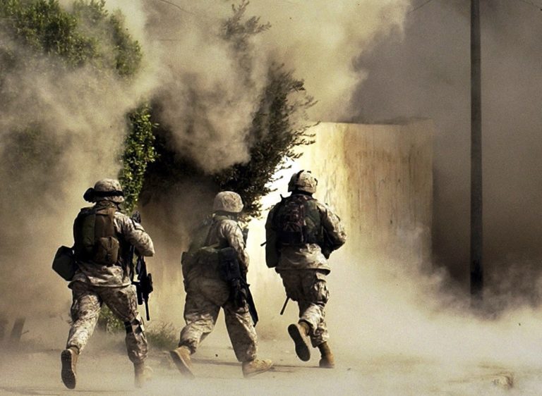 In this Oct. 26, 2004 photo, U.S. Marines from the 2nd Battalion, 5th Marine Regiment, run to a building after detonating explosives to open a gate and engage the enemy during a mission in Ramadi in Anbar province, Iraq.