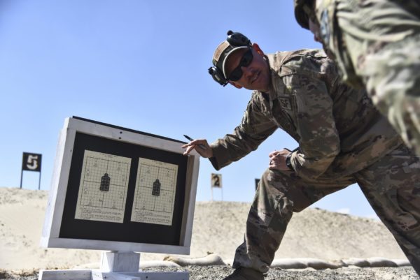 US soldiers discussing zeroing targets on a shooting range
