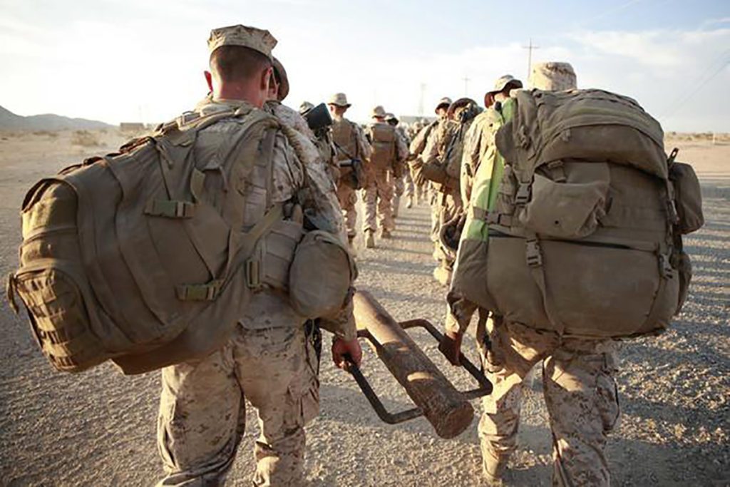 US Marines carrying heavy equipment