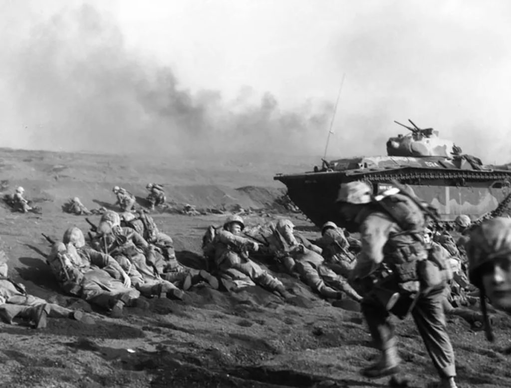 U.S. Marines of the Second Battalion, Twenty-Seventh Regiment, wait to move inland on Iwo Jima, soon after going ashore on 19 February 1945 