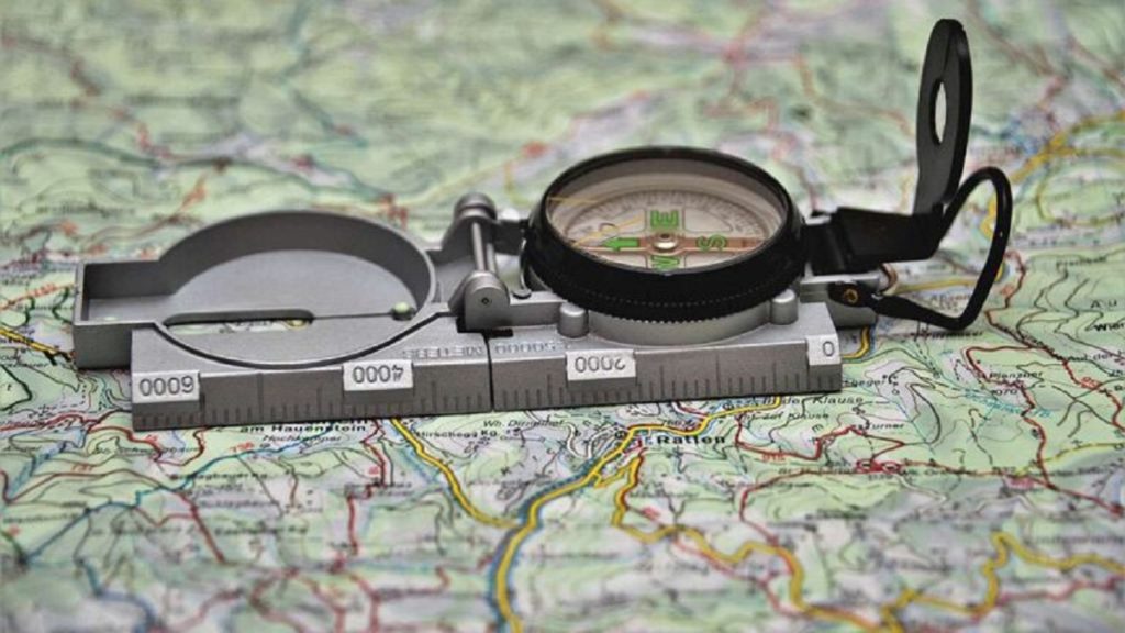 a military lensatic compass and a map