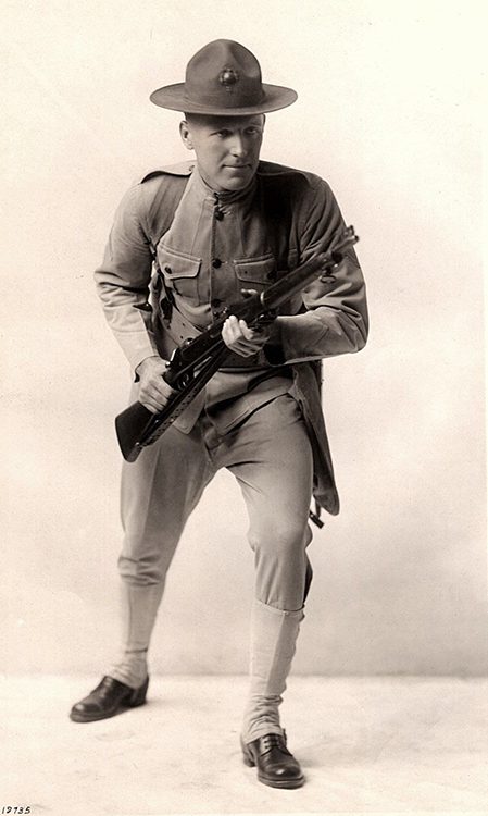 a black and white photo of a Marine (pre WWII) wearing a stiff campaign hat