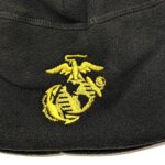 a black fleece watch cap with a gold embroidered Marine Corps EGA