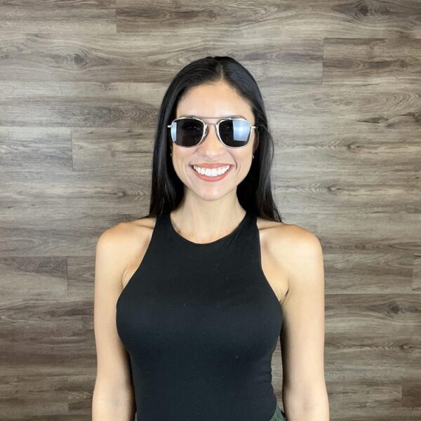 a smiling woman in black with dark lens aviator sunglasses