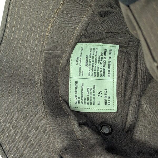 the tag of a government contractor-manufactured dark brown boonie hat