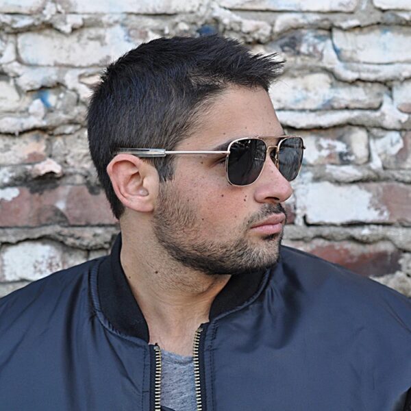 side view of a man wearing gold-framed aviator sunglasses