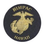 a black matte coin with a gold Marine Corps EGA (Eagle, Globe, & Anchor) and the words "RIMPAC" and "Hawaii"