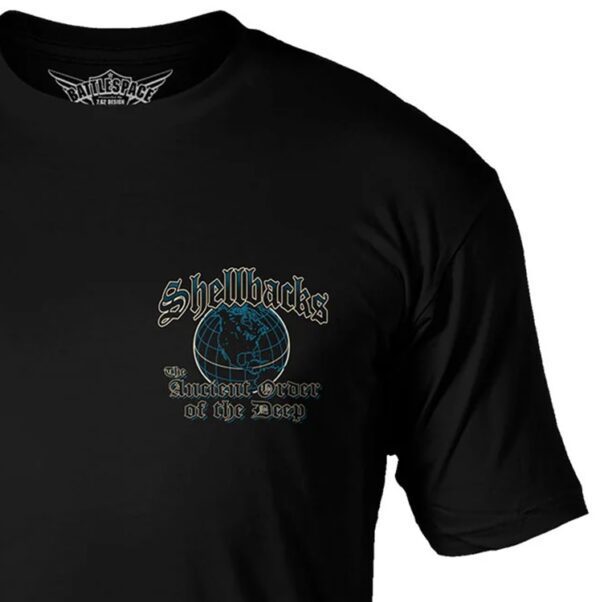 a closeup of a black US Navy and USMC shirt with a blue globe that says "Shellbacks The Ancient Order of the Deep"