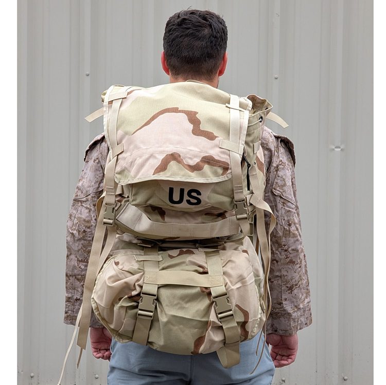 a Marine wearing a desert MARPAT FROG combat shirt wears a 3-color desert USGI MOLLE II Large Ruck Sack
