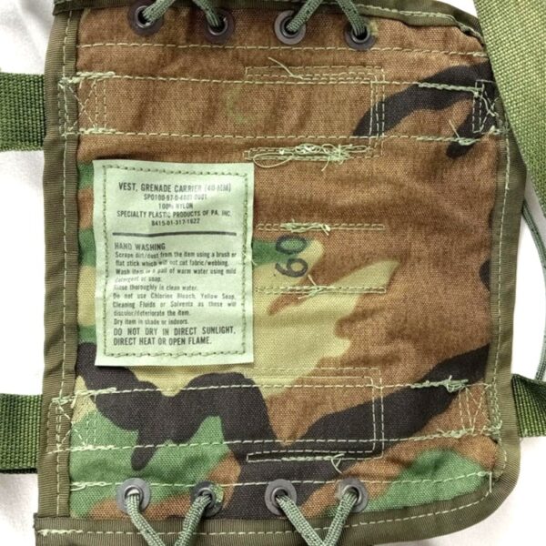 the tag on a the inside of a woodland camouflage grenade carrier vest