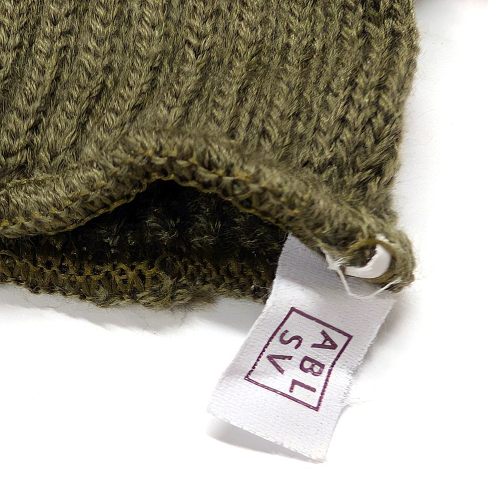 the tag and wool fabric of green Swedish cold weather gloves