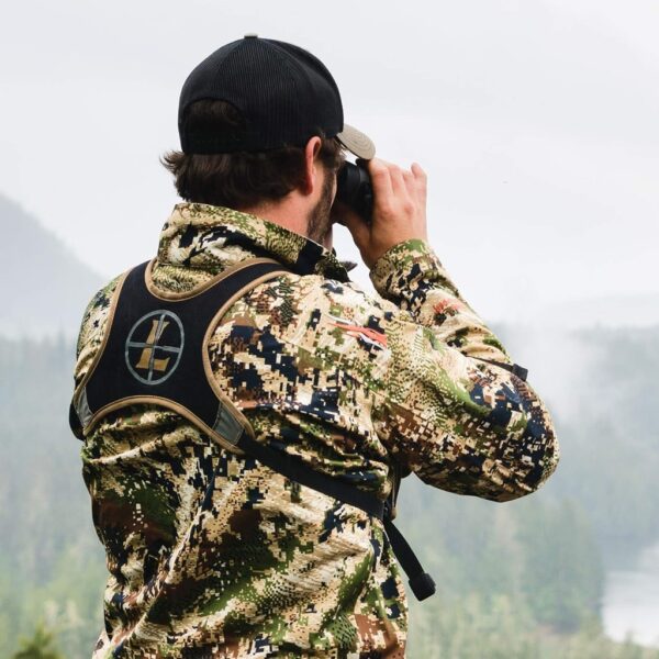 a hunter in digital camo using binoculars