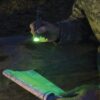 a green 12-hour light stick illuminates a map in the dark