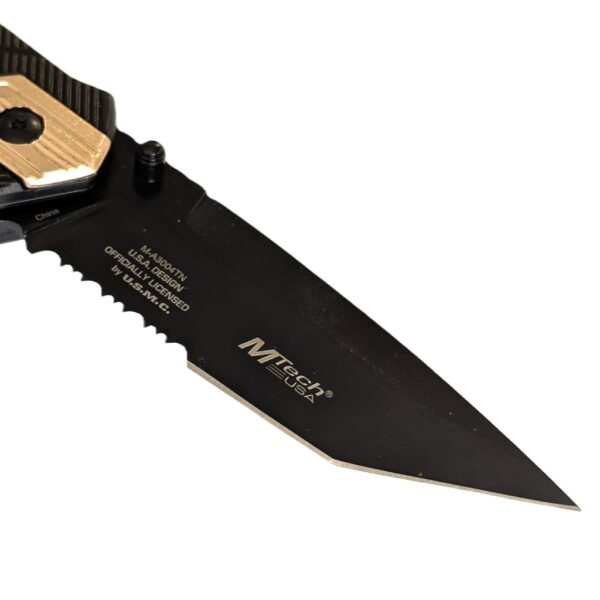 a black pocket knife with gold highlights with a US Marine Corps seal and a serrated blade with a tanto tip
