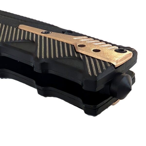 a black pocket knife with gold highlights with a US Marine Corps seal and a serrated blade with a tanto tip
