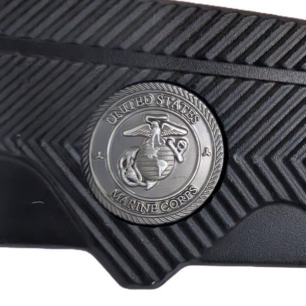 a black pocket knife with gold highlights with a US Marine Corps seal and a serrated blade with a tanto tip